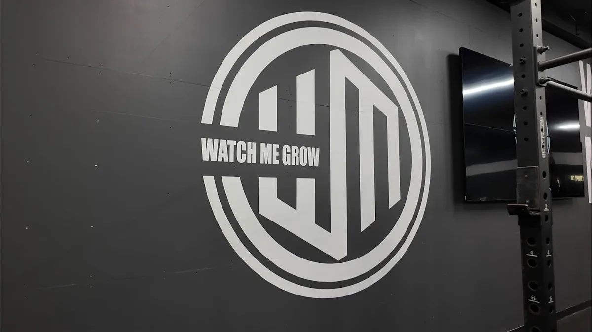 Watch Me Grow logo wall beside the strength racks